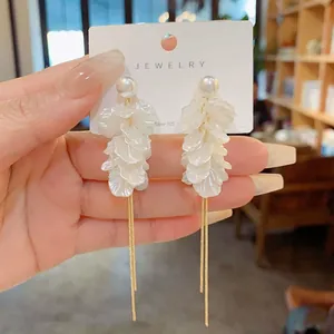 Close-up of pearl petal earrings with long golden tassels and Silver 925 needles