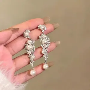 Elegant silver needle dangle earrings with pearls and crystals in a petal fringe design.