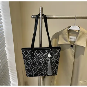 Detail view of a New Chinese style canvas tote bag with geometric patterns and a tassel