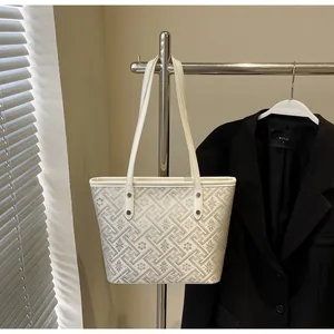 Elegant cream canvas tote bag with geometric floral pattern hanging on a rack