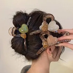 Detail view of colorful heart-shaped resin hair claws on a bun hairstyle