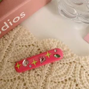 Detailed view of a pink Y2K style hair clip featuring colorful rhinestones and stars.