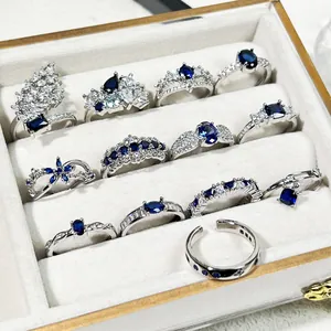 Detailansicht einer silbernen Schmuckschatulle mit blauen Zirkon- und Kristallringen.