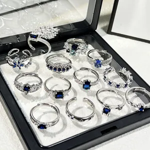 Detailansicht mehrerer eleganter Ringe mit blauen Zirkonia in einer schwarzen Schmuckschatulle