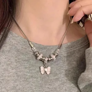 Detailed macro view of a pink bow pendant necklace with decorative silver beads