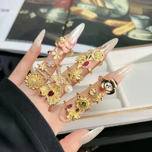 Detailansicht verzierter vergoldeter Barockringe mit 3D-Blumendesigns und Perlen.