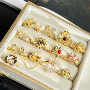 Detailansicht von barocken Goldblumenringen mit Zirkonia und Perlen in einer Schmuckschatulle