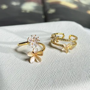 Detaillierte Nahaufnahme von Goldblumenringen mit Kristallen und opalähnlichen Blüten.