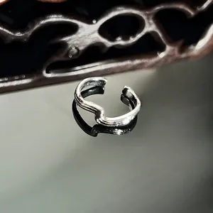 High-definition detail of a silver wavy snake-shaped ring with micro-pave stones