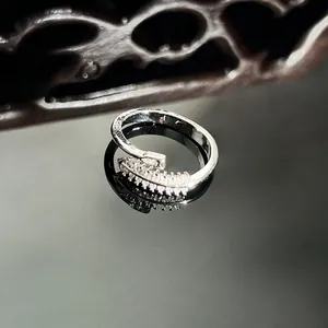 Macro detail view of an elegant silver snake-shaped ring with micro-pavé sparkling crystals