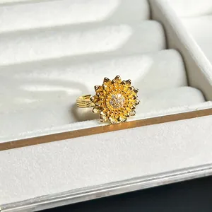 Detaillierte Nahaufnahme eines goldenen 3D-Blumenrings mit Kristallen in einer Box.