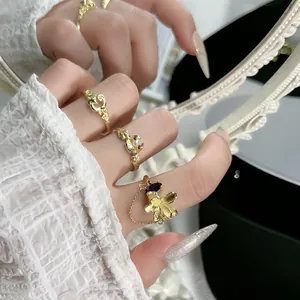 Primer plano detallado de anillos de flores dorados con cadenas de borlas y perlas.