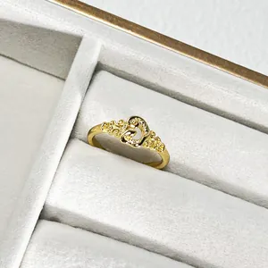 Primer plano de un anillo de corazón dorado filigrana con un elegante acabado cepillado