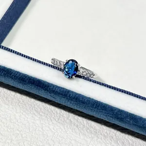 Nahaufnahme des ovalen blauen Zirkon-Edelsteins auf einem eleganten, minimalistischen Silberring