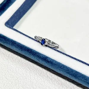 Detailansicht eines silberfarbenen verstellbaren Rings mit blauem Zirkon und klaren Steinen.