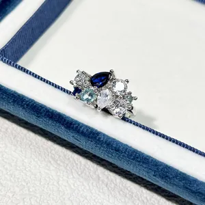 Detaillierte Makroansicht von blauen und klaren Zirkoniasteinen auf einem Silberring.