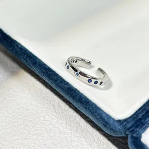 Detailansicht eines silbernen offenen Rings mit blauen Zirkoniasteinen und Stern