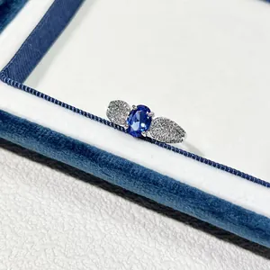 Makroaufnahme eines Silberrings mit einem ovalen blauen Zirkon und Blattdetails