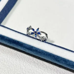 Detailansicht eines offenen Rings mit blauen Zirkonia-Blüten und Silberoberfläche