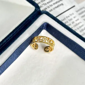 Detailansicht eines vintage goldenen Rings mit filigranem Hohlmuster und Zirkonia-Steinen