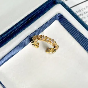 Makrodetail eines französischen goldenen Rings im Retro-Stil mit funkelnden Zirkoniasteinen
