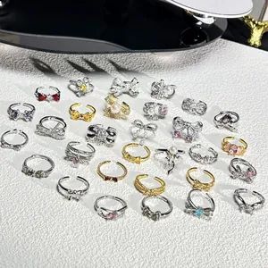 Collection détaillée de bagues nœuds élégantes avec zircons et perles colorés.
