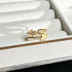 Zweilagiger Goldring mit 3D-Blumenmotiven und Pavé-Steinen in einer Schmuckschatulle
