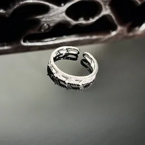 Detailed macro shot of an elegant silver snake-shaped ring with micro-inlaid stones