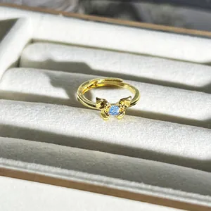 Detail eines goldenen Schmetterlingsrings mit hellblauem Schmuckstein in Samtbox