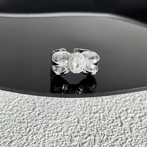 Gros plan d'une bague nœud en argent avec un cristal ovale scintillant au centre
