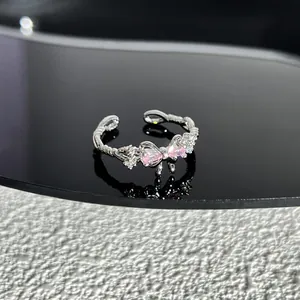Vue détaillée d'une bague nœud en argent avec des pierres roses et un anneau torsadé.