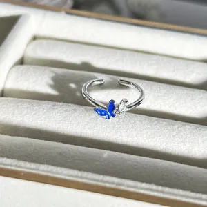 Detailaufnahme eines exquisiten silbernen Schmetterlingsrings mit blauer Emaille und Kristallen.