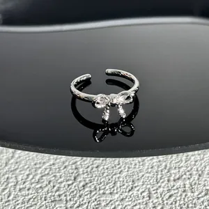 Gros plan d'une bague nœud argentée élégante ornée de pierres de zircone brillantes