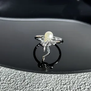Gros plan détaillé d'une bague à nœud argentée ornée d'une perle blanche centrale