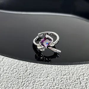 Gros plan d'une bague nœud argentée ornée d'une magnifique pierre rectangulaire violette.