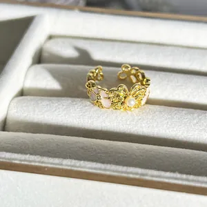 Eleganter goldener Schmetterlings- und Blumenring mit Perlendetail in Schmuckschatulle.