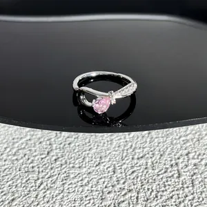 Gros plan détaillé d'une bague élégante en argent avec nœud et pierre rose en poire