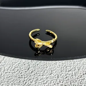 Détail d'une bague nœud dorée ajustable avec des accents de zircon étincelants