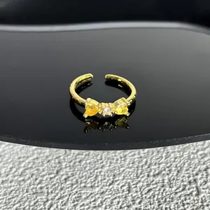 Vue rapprochée détaillée d'une élégante bague nœud dorée avec des cristaux cœur jaunes
