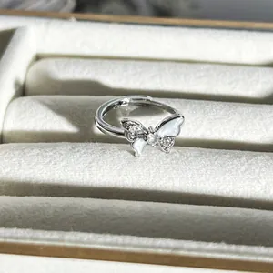 Detailansicht eines eleganten Silberrings mit Schmetterling und weißen Einlagen in Box.