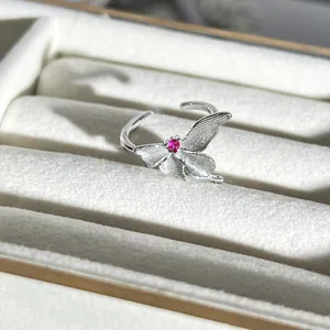 Detaillierte Makroaufnahme eines silbernen Schmetterlingsrings mit rosa Schmuckstein