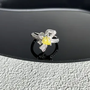 Vue détaillée bague nœud en argent avec pierre cœur jaune et pavé de cristaux