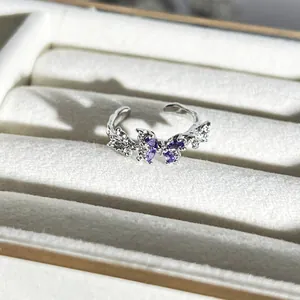 Detailaufnahme eines eleganten silbernen Schmetterlingsrings mit lila Zirkonia