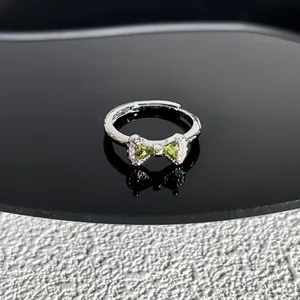 Vue détaillée d'une bague nœud en argent ornée de pierres précieuses vert clair éclatantes