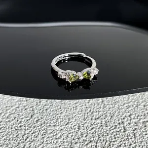 Gros plan détaillé d'une bague nœud élégante avec des pierres vert olive en cœur