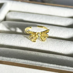 Detailaufnahme eines zarten goldenen Schmetterlingsrings mit feinem filigranem Design