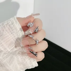 Detailed view of silver open rings with marquise-cut zircons worn on fingers