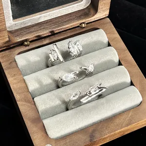 Detailed view of marquise zircon open rings in a wooden jewelry box display.