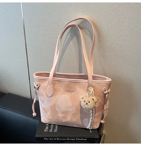 Elegante bolso tote rosa jaspeado con un bonito colgante de oso y correas de hombro