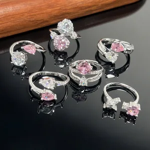 Close-up of elegant adjustable silver rings with pink and clear teardrop zirconia.
